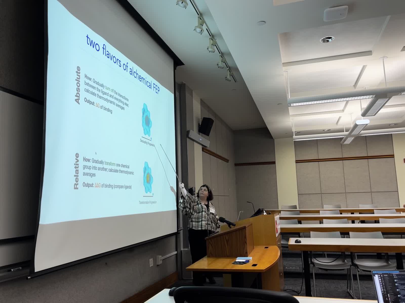 Presenter speaking in front of screen at Rutgers symposium